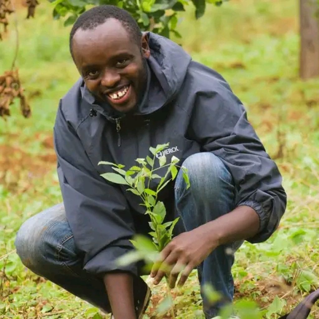A youth planting a tree during a community event