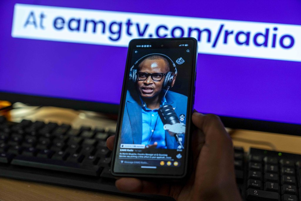 A person watching a vertical TikTok video featuring EAMG Radio content on a smartphone screen