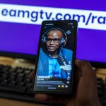A person watching a vertical TikTok video featuring EAMG Radio content on a smartphone screen